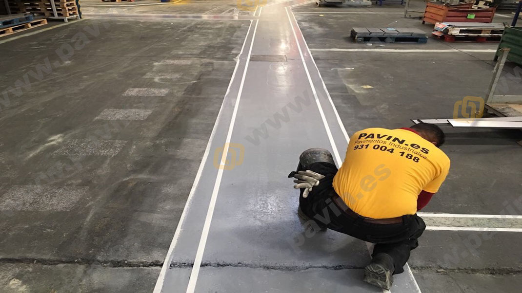 colocación de la cinta en el pavimento de hormigón para la señalización industrial para automoción