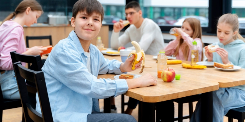 Niños comiendo en comedor escolar con pavimento continuo de fácil limpieza