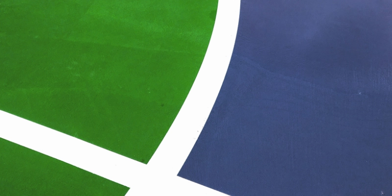 Detalle de pista polideportiva con líneas blancas sobre pavimento verde y azul