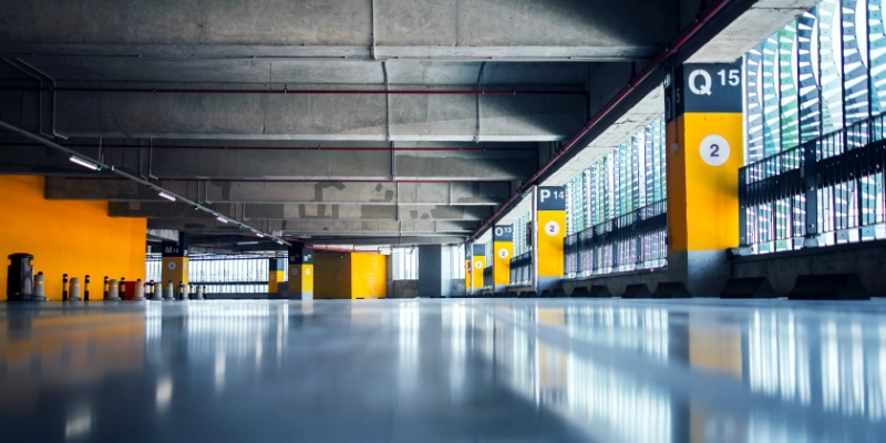 Garaje cubierto con pavimento epoxi gris y columnas amarillas numeradas