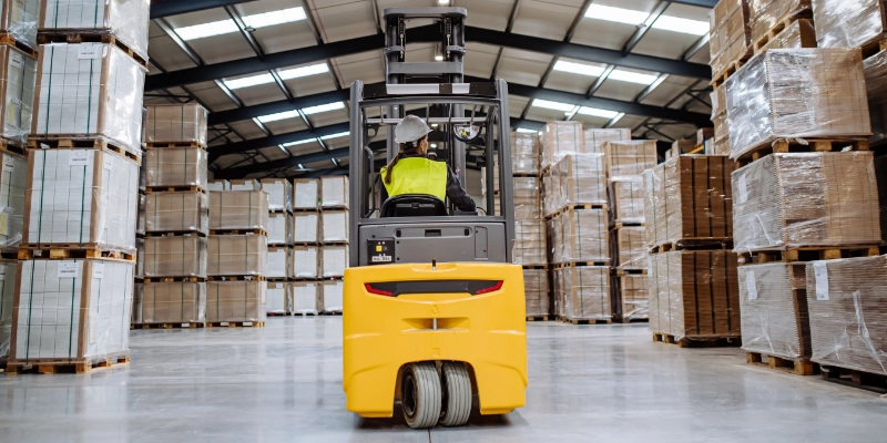 Carretilla elevadora transportando pallets en almacén logístico moderno