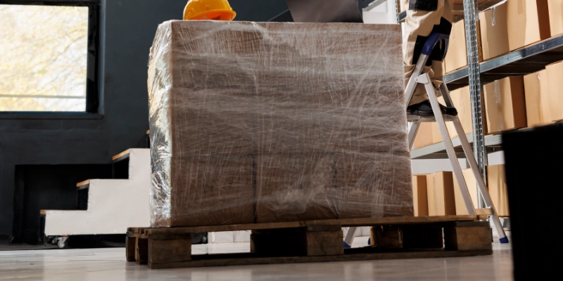 Trabajadora organizando cajas en estanterías de almacén logístico textil