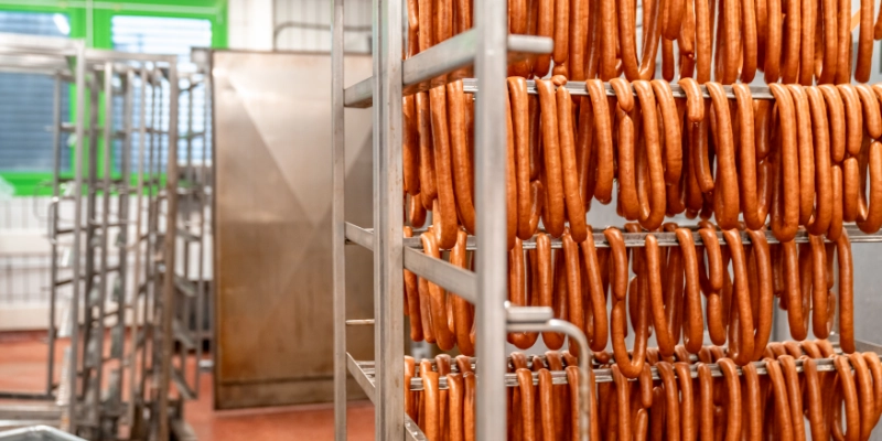 Estructuras industriales con embutidos en secado dentro de planta cárnica